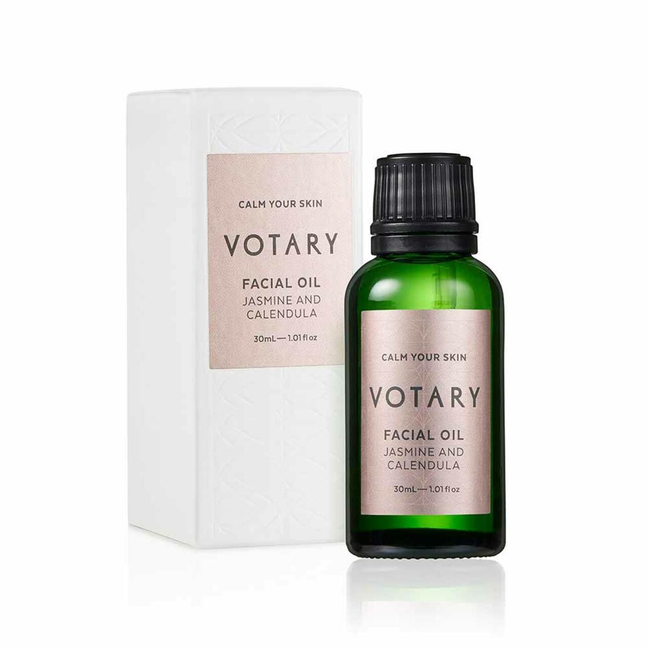 Grüne Glasflasche und weiße Verpackung. Etikett mit Text: Votary Facial Oil Jasmine & Calendula. 30ml.