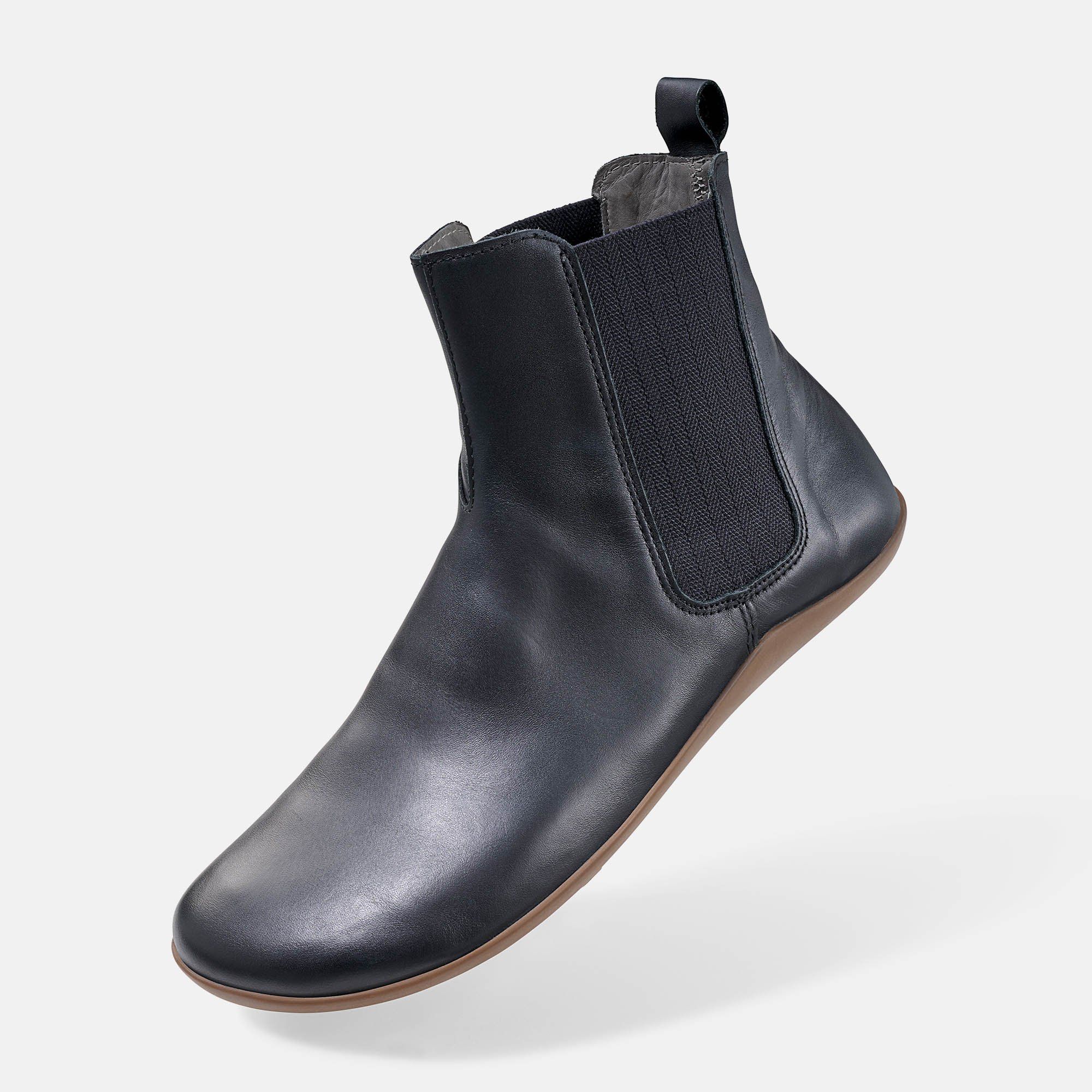 Schwarze Stiefelette mit brauner Sohle. Elastischer Einsatz an der Seite. Schuh von der Seite.