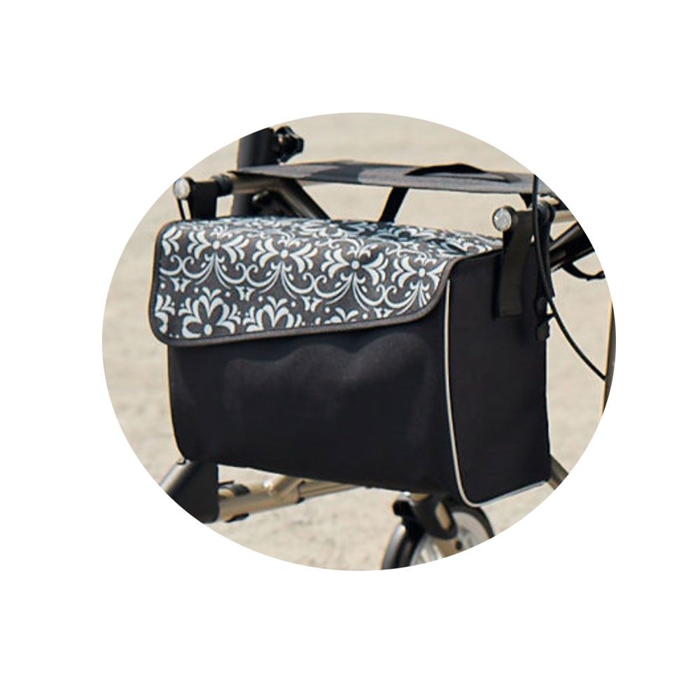 Schwarze Tasche mit Magnetverschluss für Rollator. Deckel mit floralem Muster. Weißer Rand. Am Rollator befestigt.