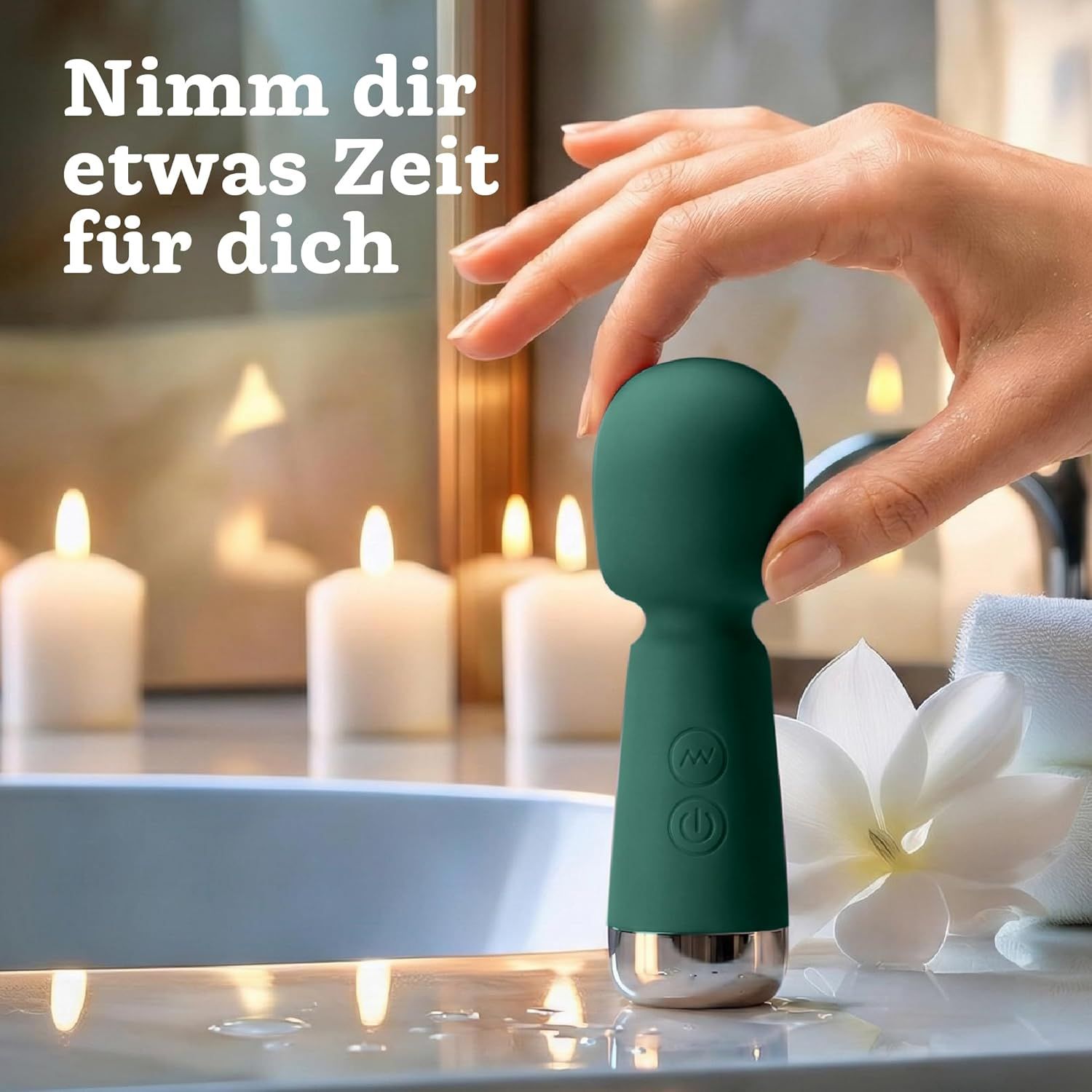 Grüner Mini-Vibrator wird in einer Hand gehalten, umgeben von Kerzenlicht und einer Blume.
