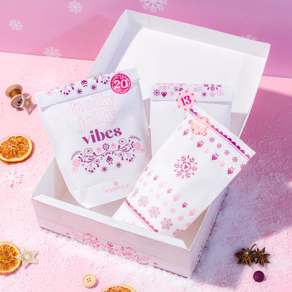 Essence Adventskalender mit Tüten. Tüten mit Aufdruck 'holly jolly vibes' und Zahlen.