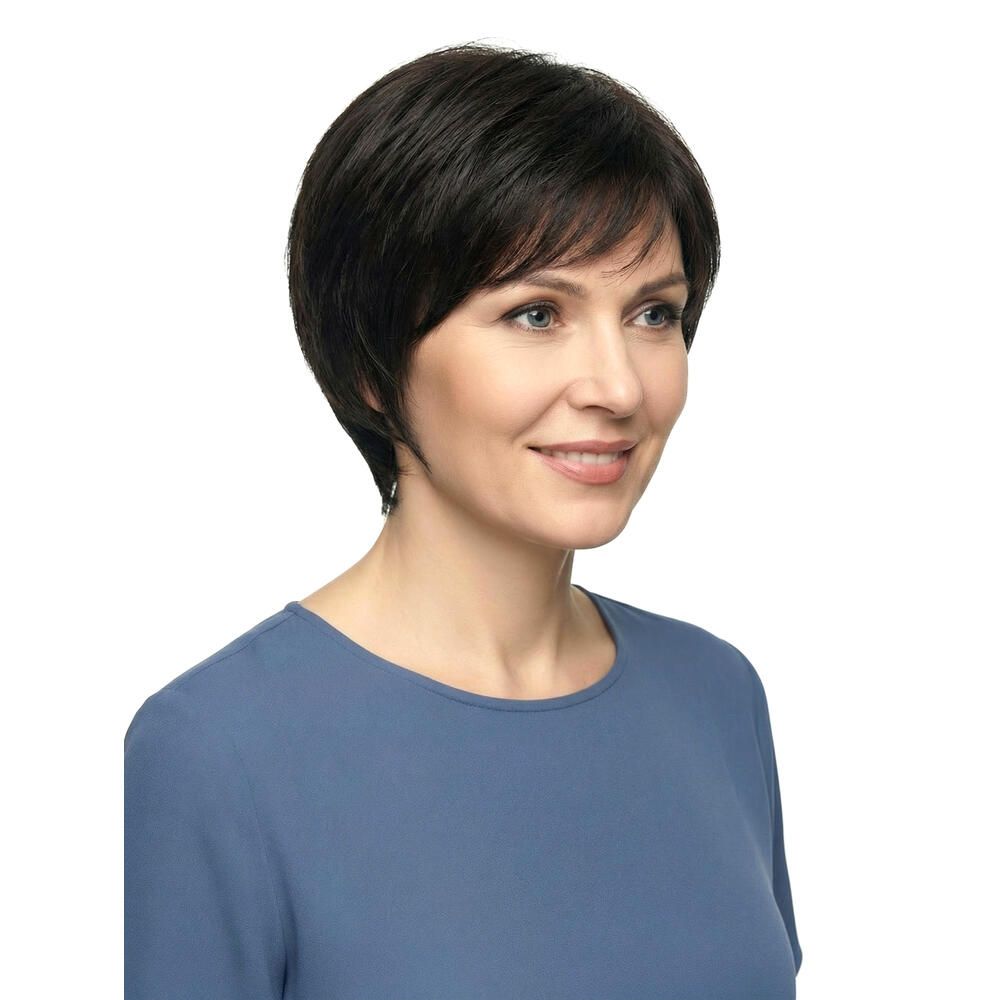 Dunkelbraune Perücke mit kurzem, gewelltem Schnitt. Die Perücke bedeckt den Kopf einer Frau, die in die Kamera lächelt.