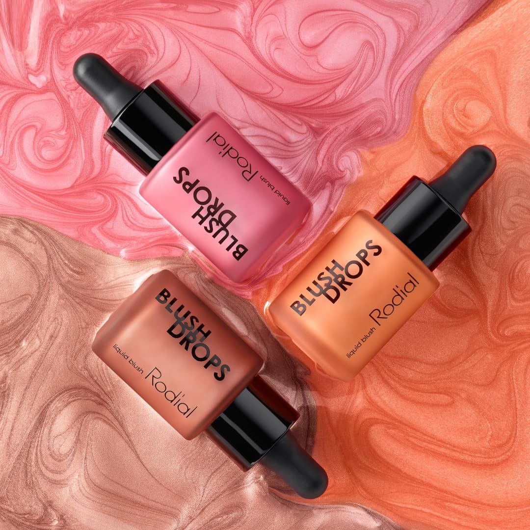 Drei Rodial Blush Drops in verschiedenen Farben auf abstraktem Hintergrund.