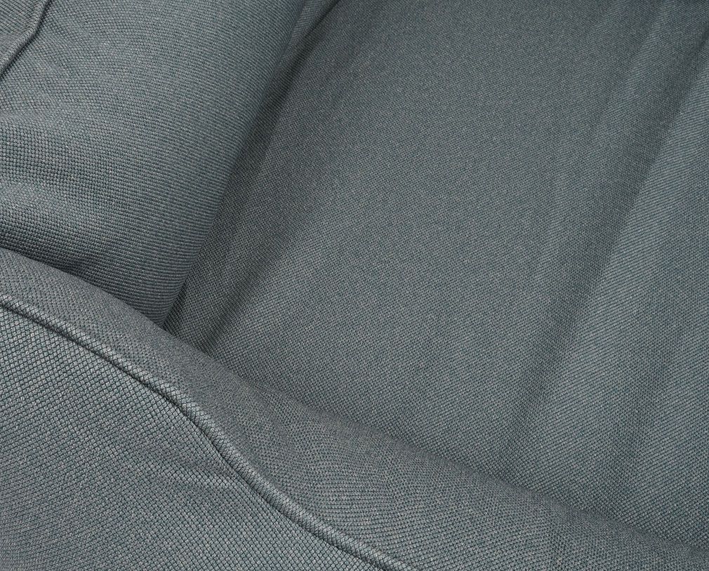 Nahaufnahme des grauen Stoffes eines Hundebetts. Textur des Materials ist erkennbar. Naht am Rand.