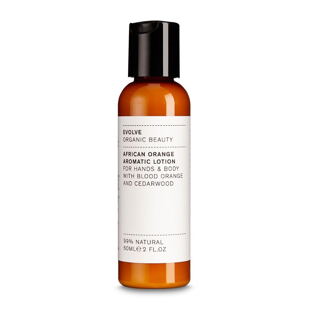 Eine Flasche Evolve African Orange Aromatic Lotion. Orangefarbene Flüssigkeit in einer Flasche mit schwarzem Deckel. Aufschrift: African Orange Aromatic Lotion.