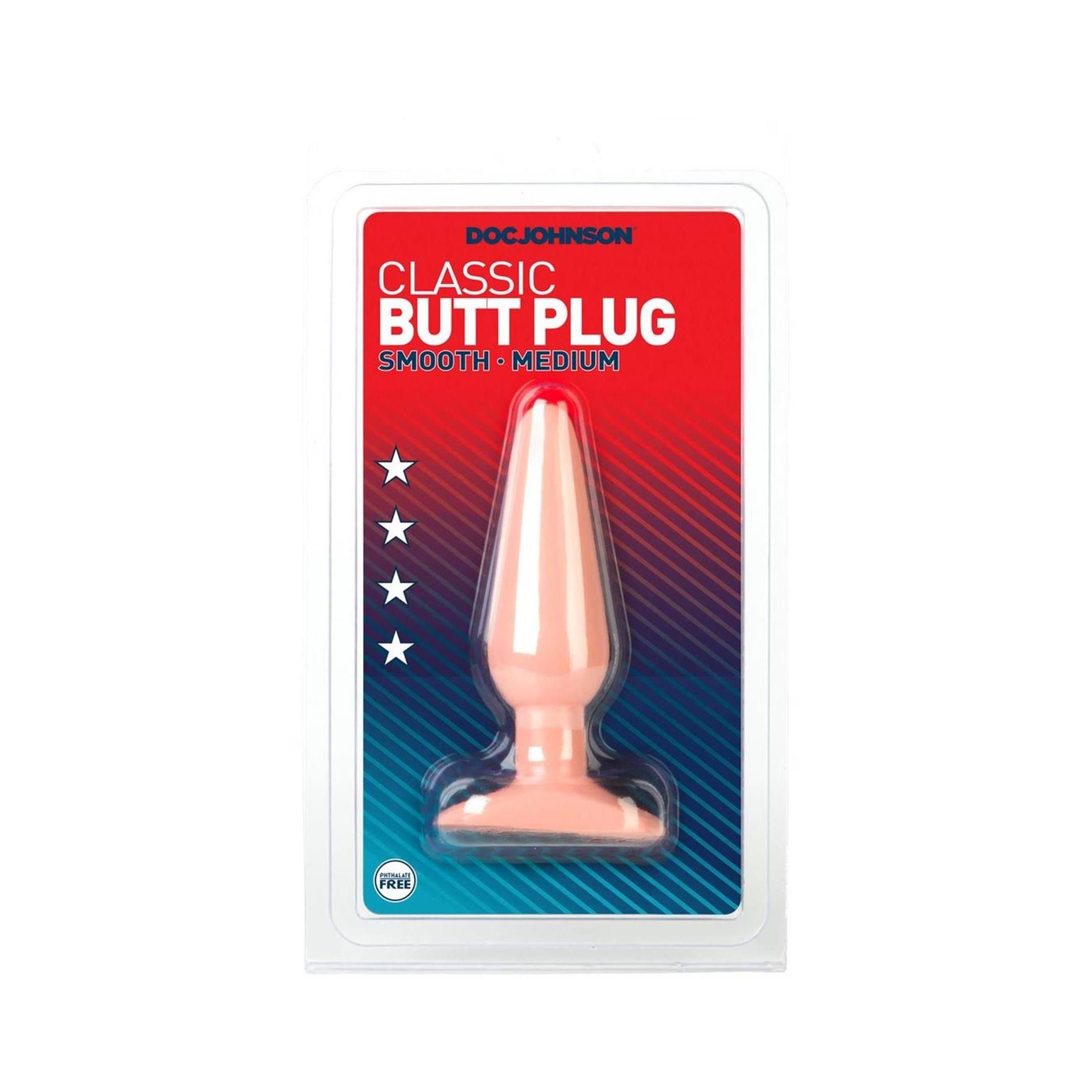 Butt Plug in Verpackung. Rosa, konisch zulaufend, mit breiter Basis. Marke: Doc Johnson. Aufschrift: Classic Butt Plug, Smooth, Medium.