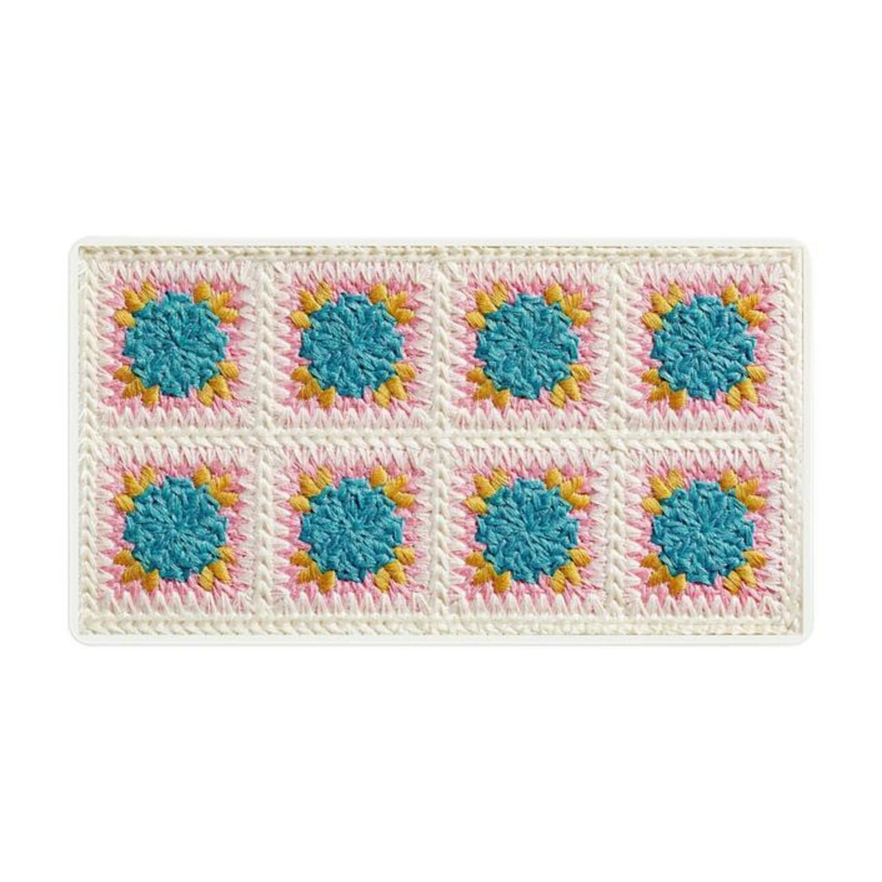 Rechteckige Kosmetikpalette mit acht quadratischen, gehäkelten Mustern in Blau, Rosa und Gelb auf weißem Hintergrund.