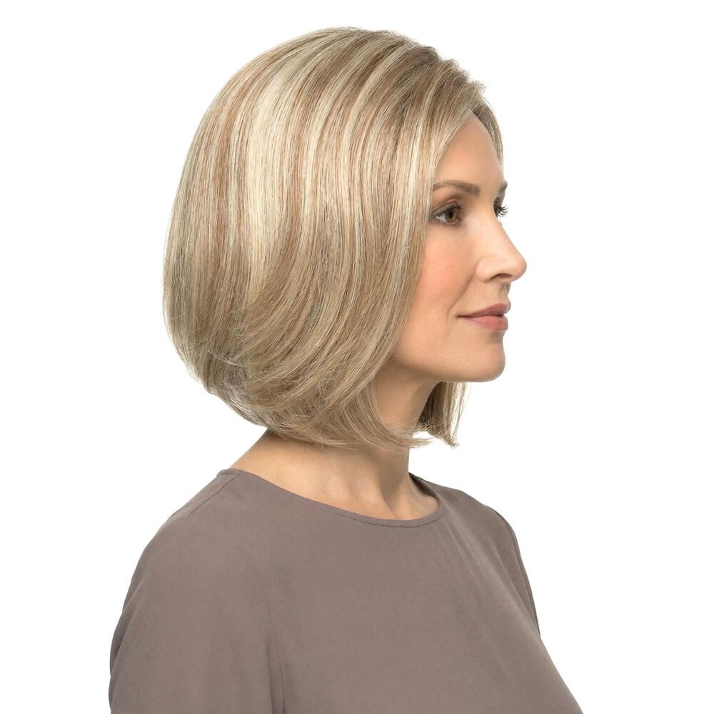 Blonde Perücke mit kurzem, gestuftem Schnitt. Die Frau trägt ein braunes Oberteil. Seitenansicht.
