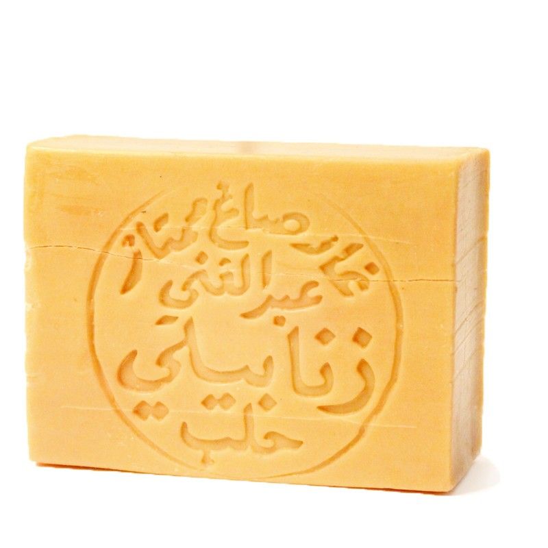 Rechteckige Seife mit eingraviertem arabischen Schriftzug. Gelbliche Farbe. Aufschrift in einem Kreis.