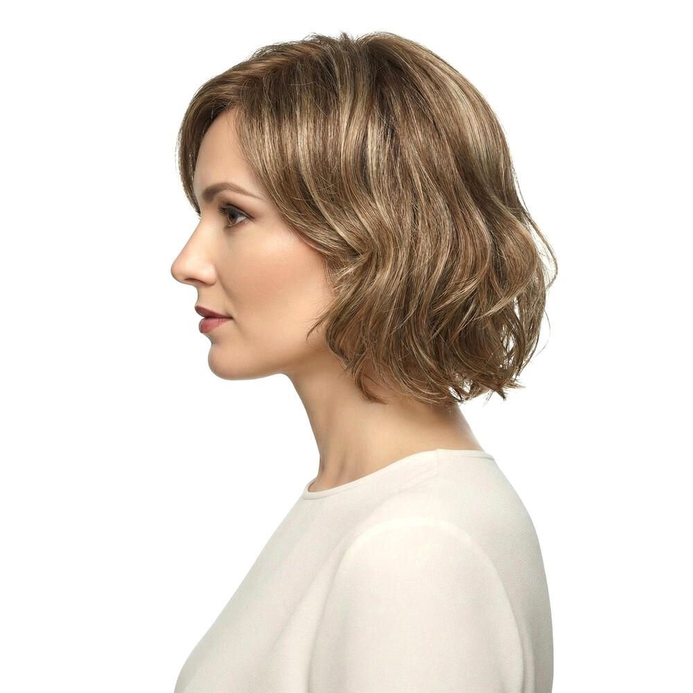 Perücke Lilie von trendhair. Kurze, gewellte Kunsthaarperücke in Blond- und Brauntönen. Seitenansicht einer Frau.