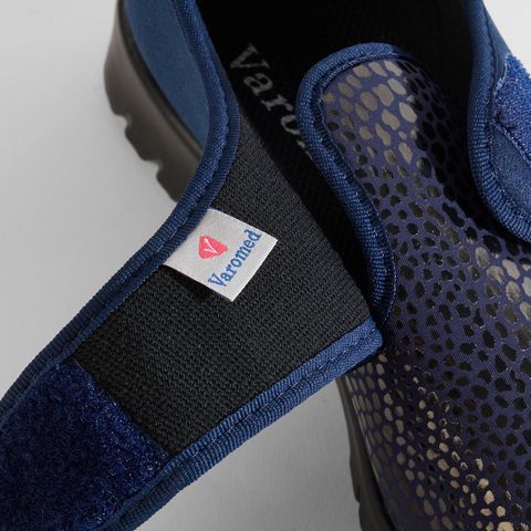 Blauer Damenschuh mit Klettverschluss und geprägtem Obermaterial. Varomed-Logo auf dem Riemen.