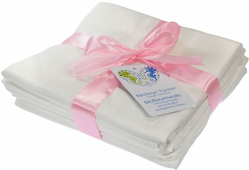 Ein Set aus weißen Mulltüchern, gebunden mit rosa Schleife. Ein Etikett mit Logo und Text ist angebracht.