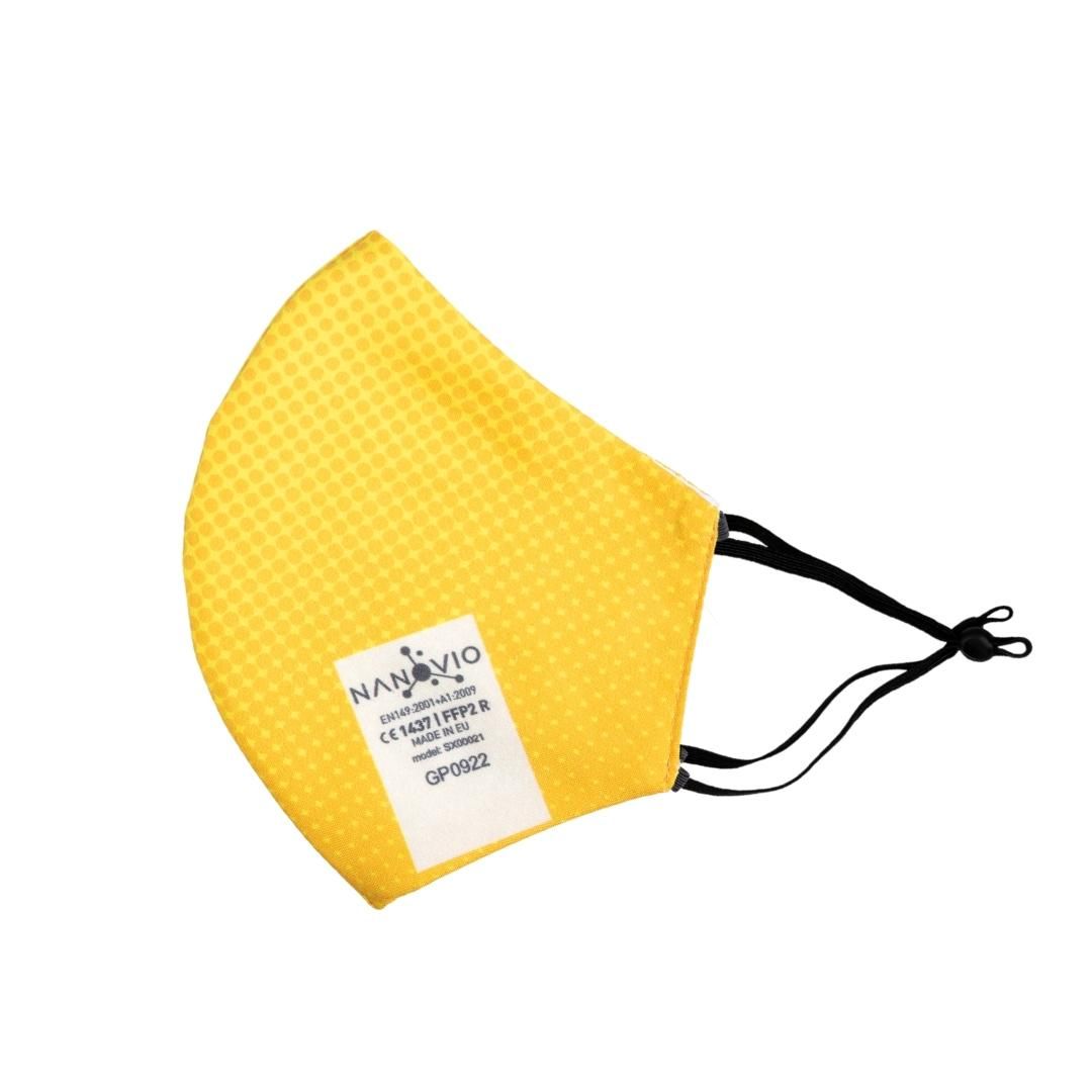 Gelbe FFP2-Maske mit schwarzem Gummiband. Auf der Maske befindet sich ein weißes Etikett mit Text und dem Logo.