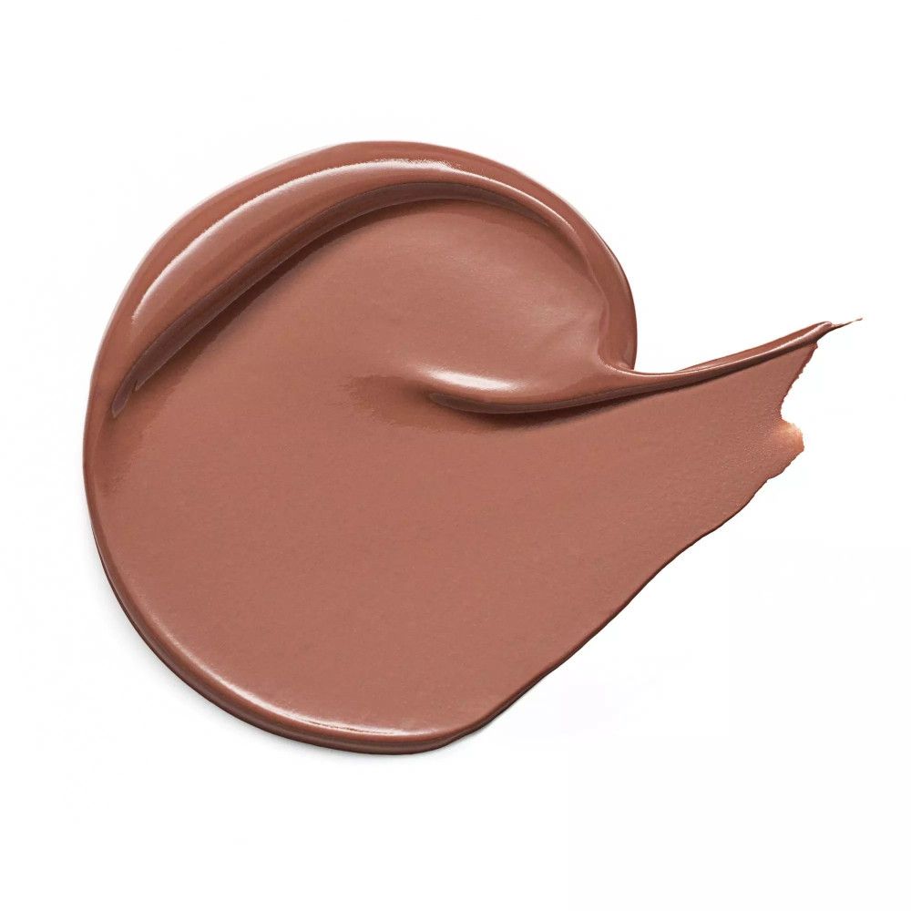 Brauner Concealer-Klecks auf weißem Hintergrund. Glatte, glänzende Textur.