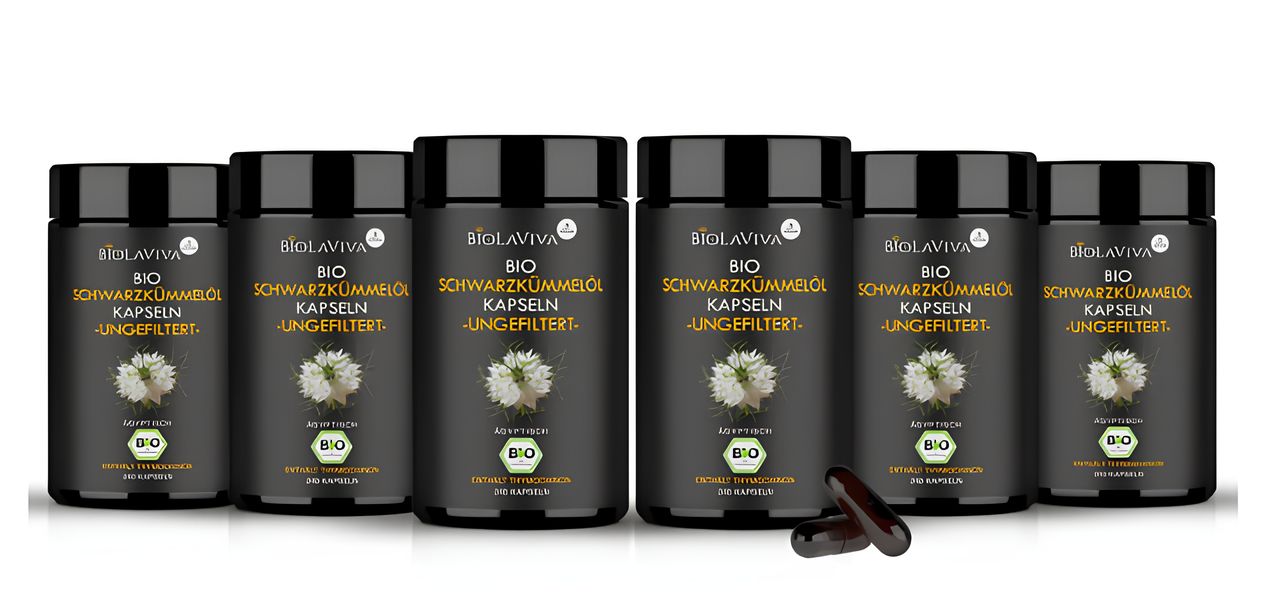 Sechs schwarze Dosen mit Kapseln. Aufschrift: BIOLAVIVA BIO Schwarzkümmelöl Kapseln. Einige Kapseln liegen daneben.