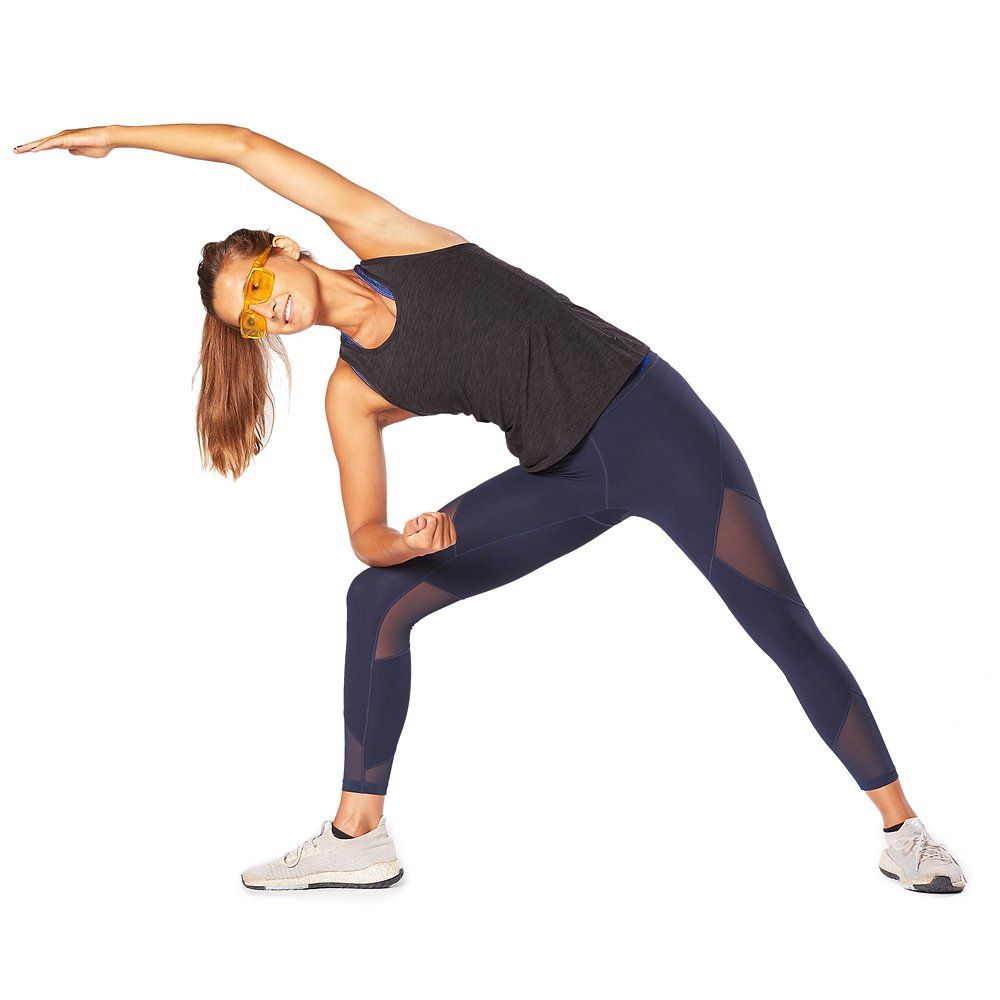 Person mit orangefarbener Brille beim Yoga. Schwarzes Top, blaue Hose.