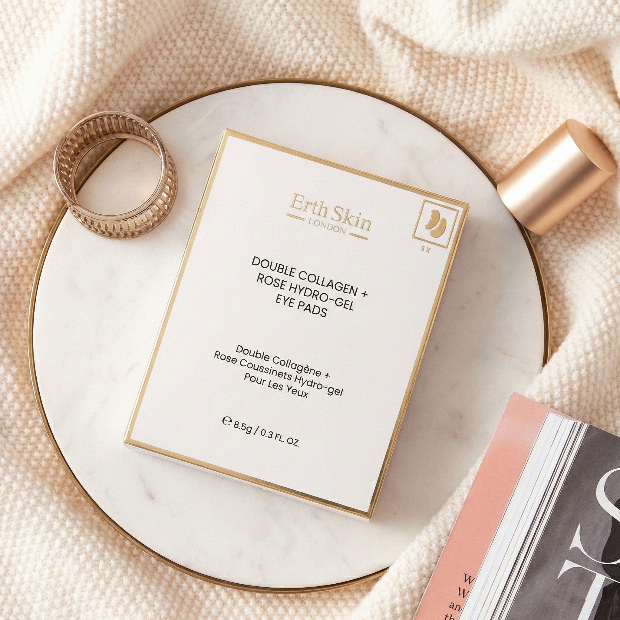 Verpackung der ErthSkin London Doppeltes Kollagen + Rose Hydrogel-Augenpads auf einem Marmorteller.