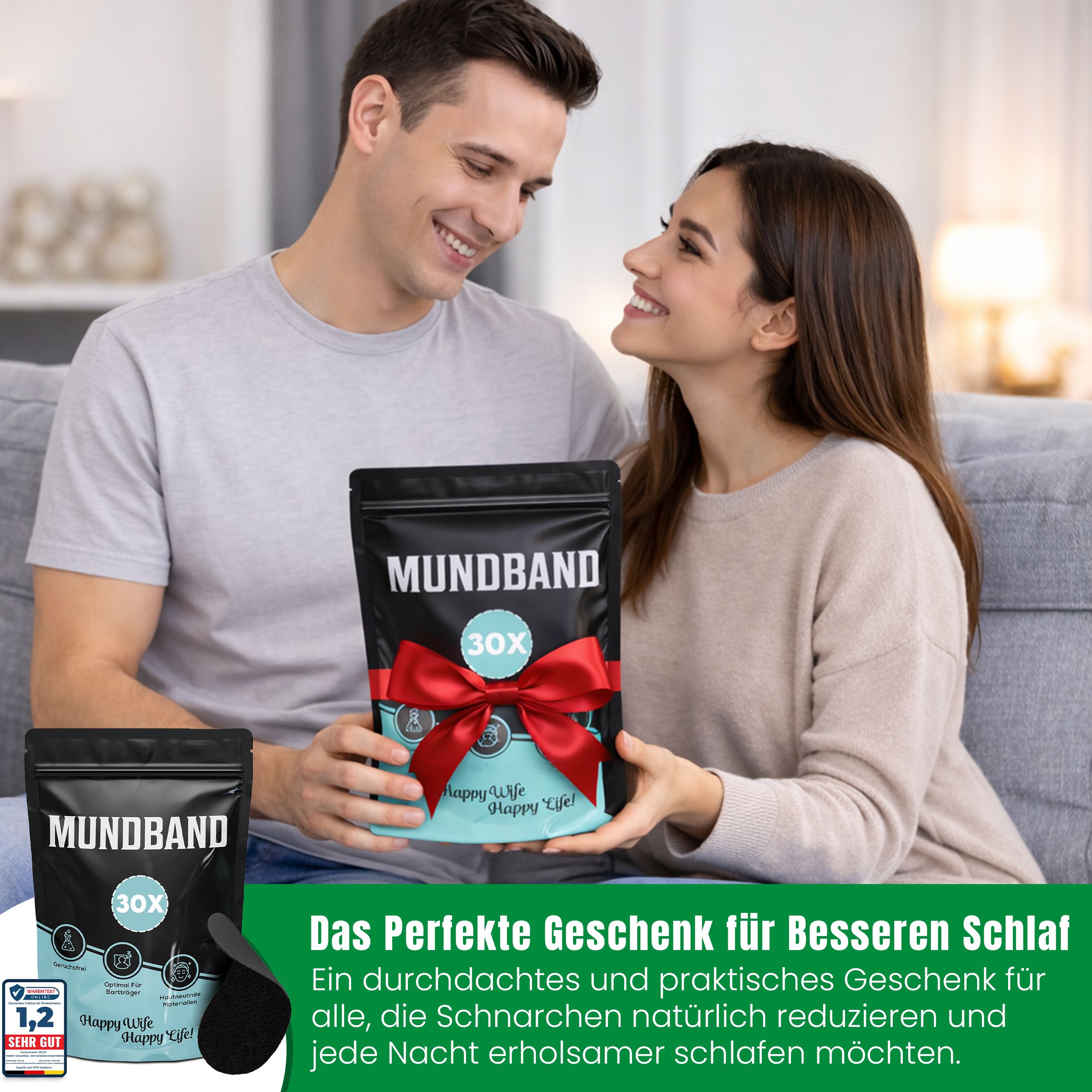 Paar auf Couch, hält Geschenkverpackung "Mundband". Rotes Band. Text: "Das perfekte Geschenk".