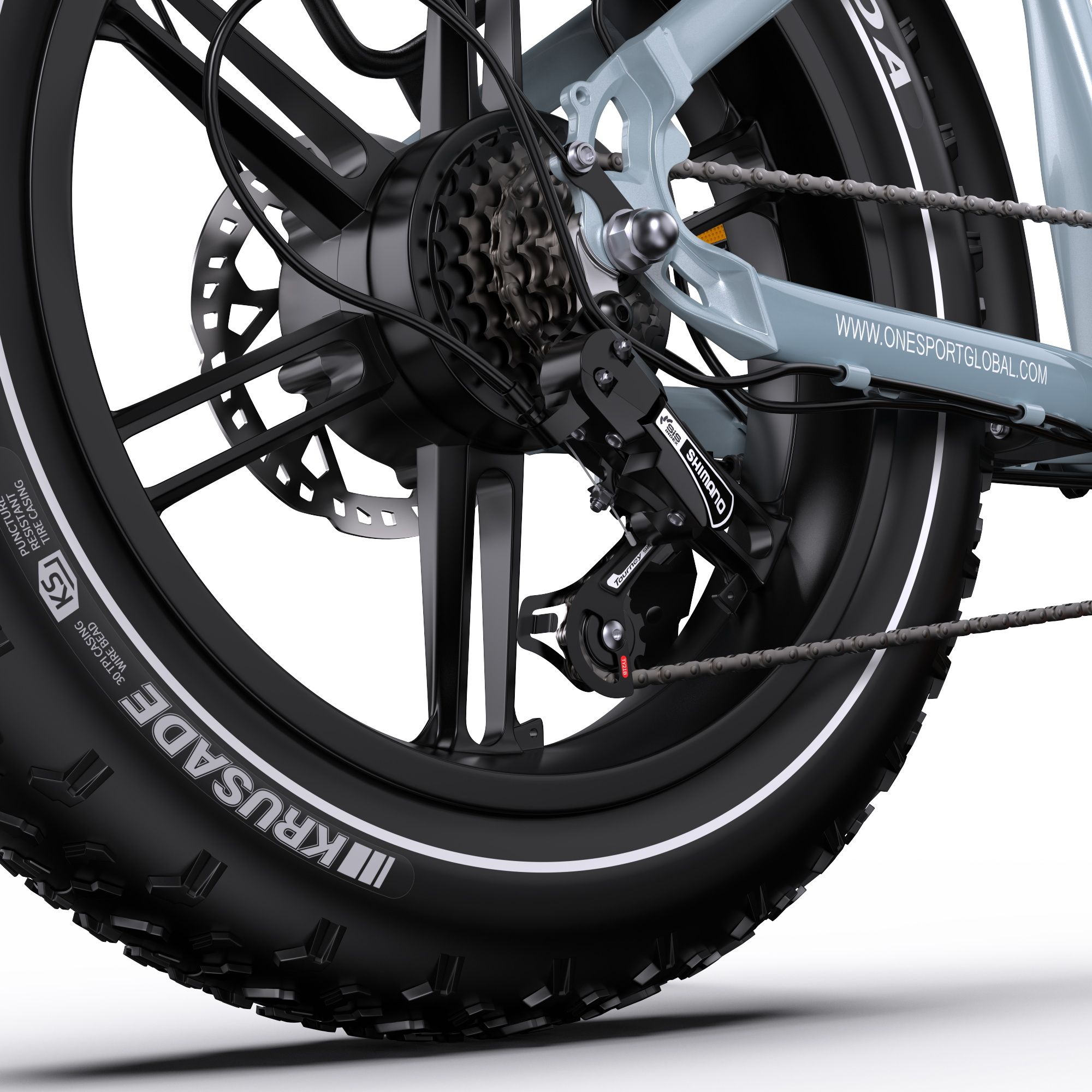 Detailansicht des Hinterrads eines E-Bikes. Sichtbar: Kenda-Reifen, Shimano-Schaltung, Scheibenbremse.