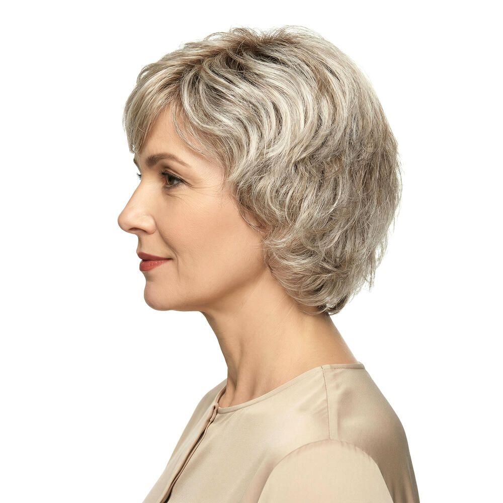 Kurzhaarperücke mit grauen Strähnen. Seitenansicht einer Frau mit beigem Oberteil. Frisur mit Wellen.