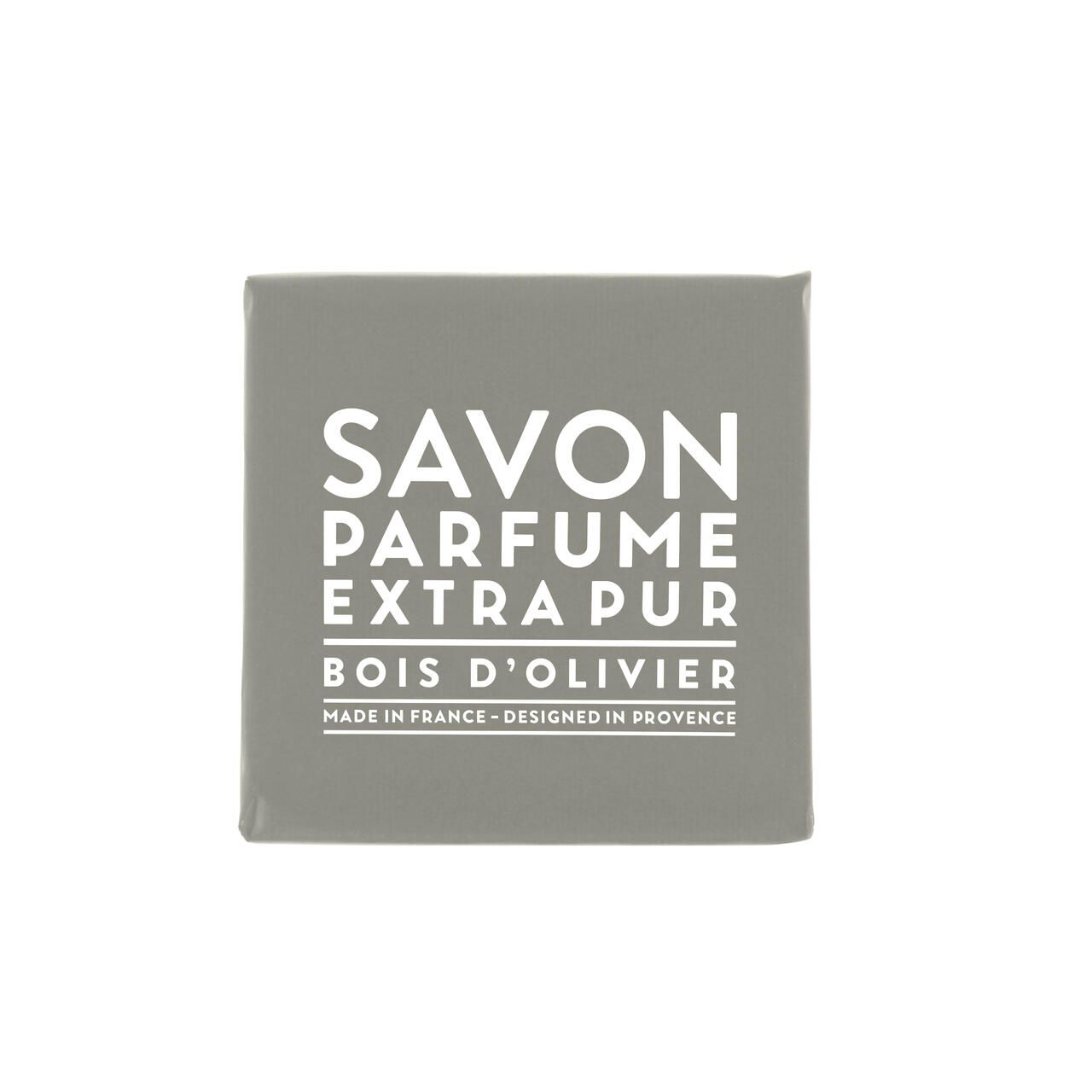 Graues Seifenstück mit weißem Text. Text: Savon Parfume Extra Pur Bois d'Olivier. Hergestellt in Frankreich, entworfen in der Provence.