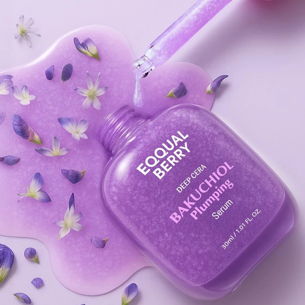 Violette Serumflasche mit Pipette. Text: EQQUAL BERRY, BAKUCHIOL Plumping Serum. Flüssigkeit und Blütenblätter daneben.