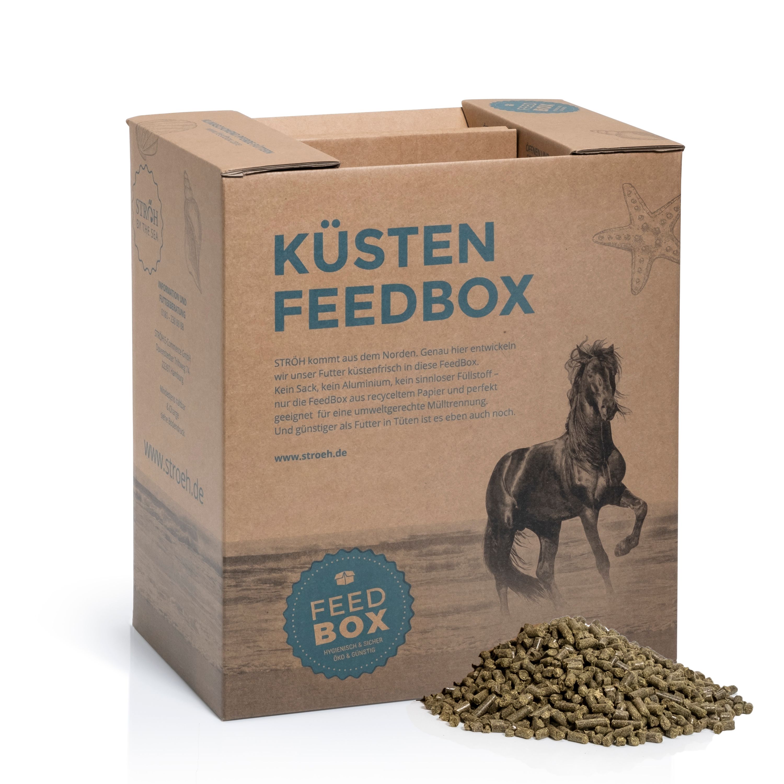 Kartonbox mit Aufdruck "KÜSTEN FEEDBOX" und Pferdeabbildung. Daneben Pellets. Marke STRÖH.