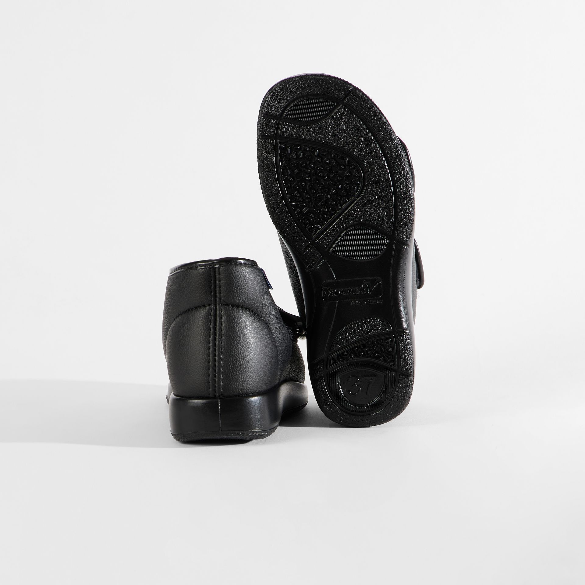 Schwarze Schuhe mit Klettverschluss und rutschfester Sohle.