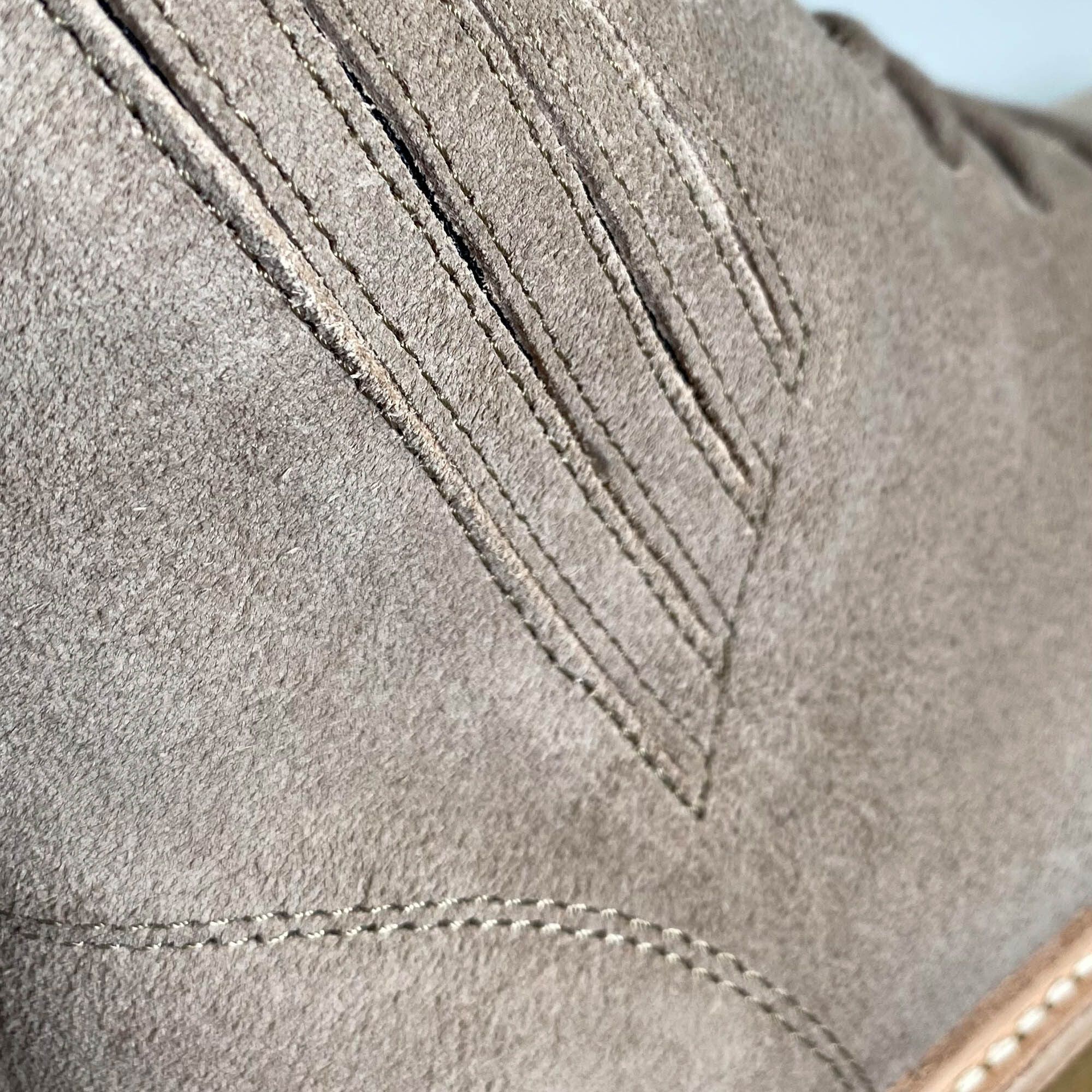 Detailansicht der Stiefelette. Genähte Details, V-förmiger Einsatz. Hellbraunes Wildleder.