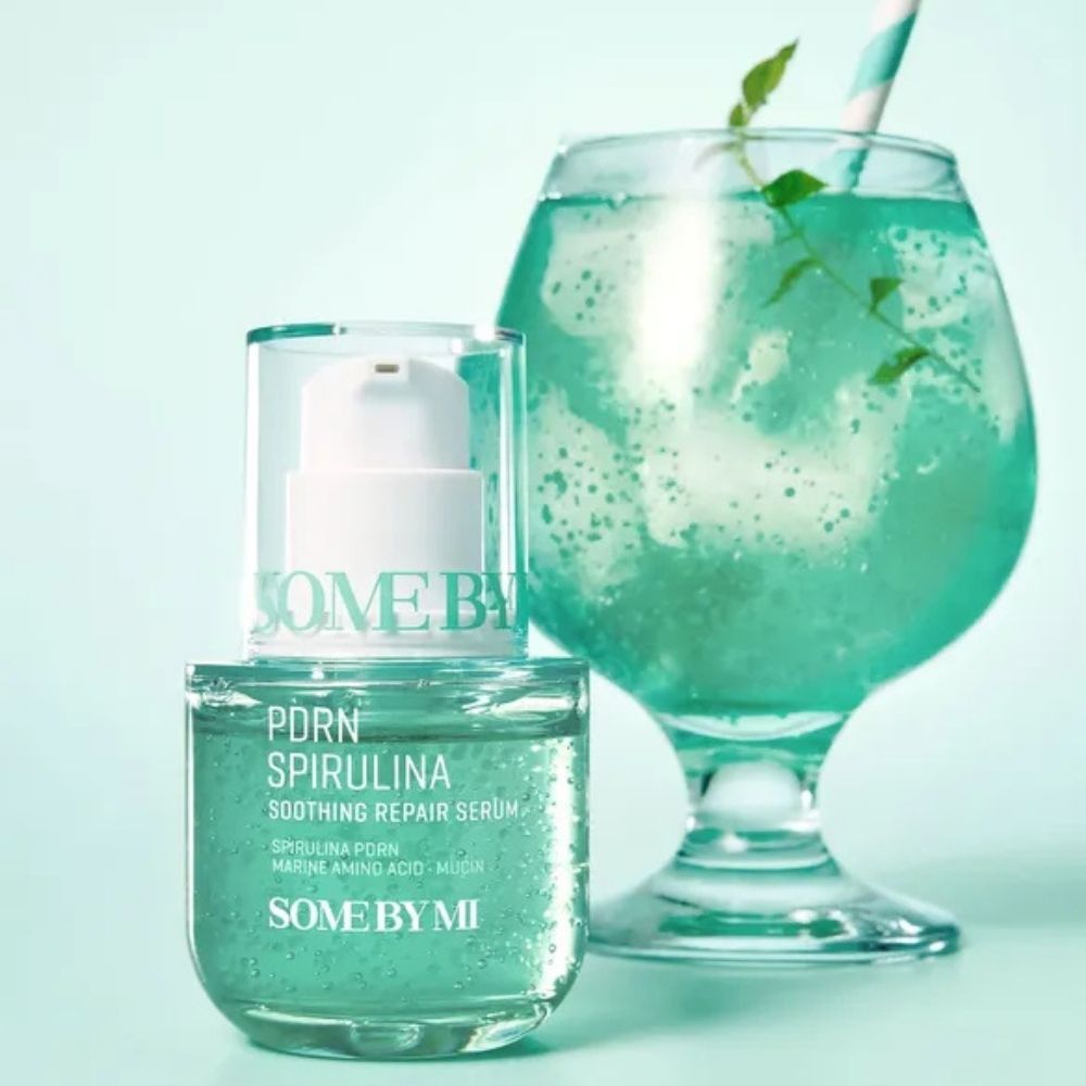 SOME BY MI PDRN Spirulina Serum neben einem blauen Getränk.