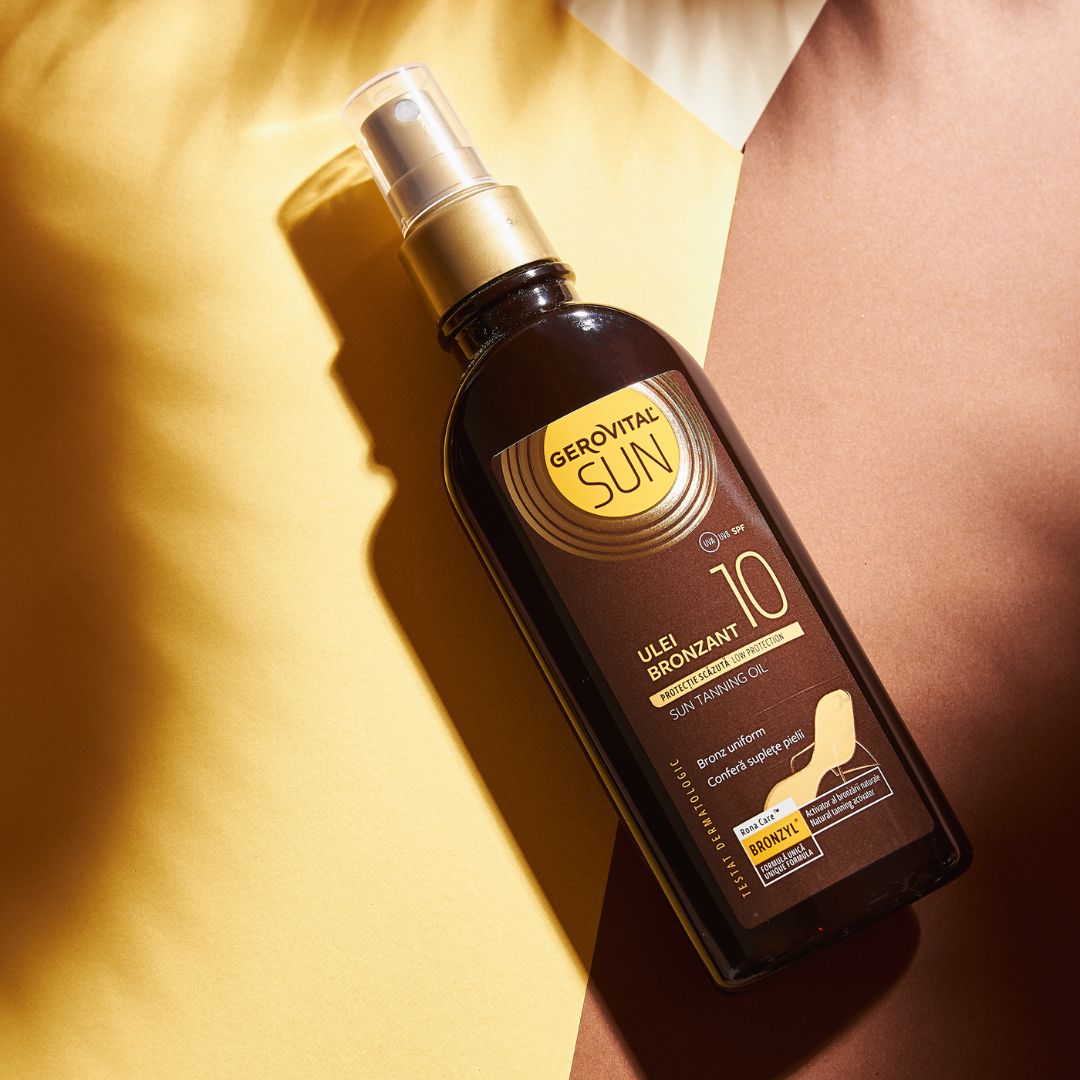 Gerovital Sun Bräunungsöl mit SPF 10, braune Flasche mit Sprühkopf. Aufschrift: Ulei Bronzant, Sun Tanning Oil. Hintergrund: gelb und braun.