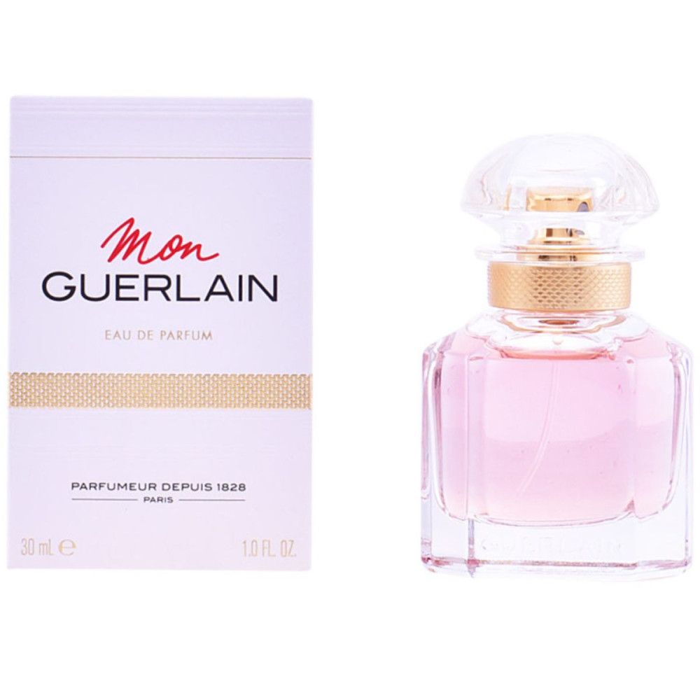 Parfümflasche mit rosa Flüssigkeit und goldfarbenem Verschluss. Daneben eine weiße Schachtel mit rotem Schriftzug.