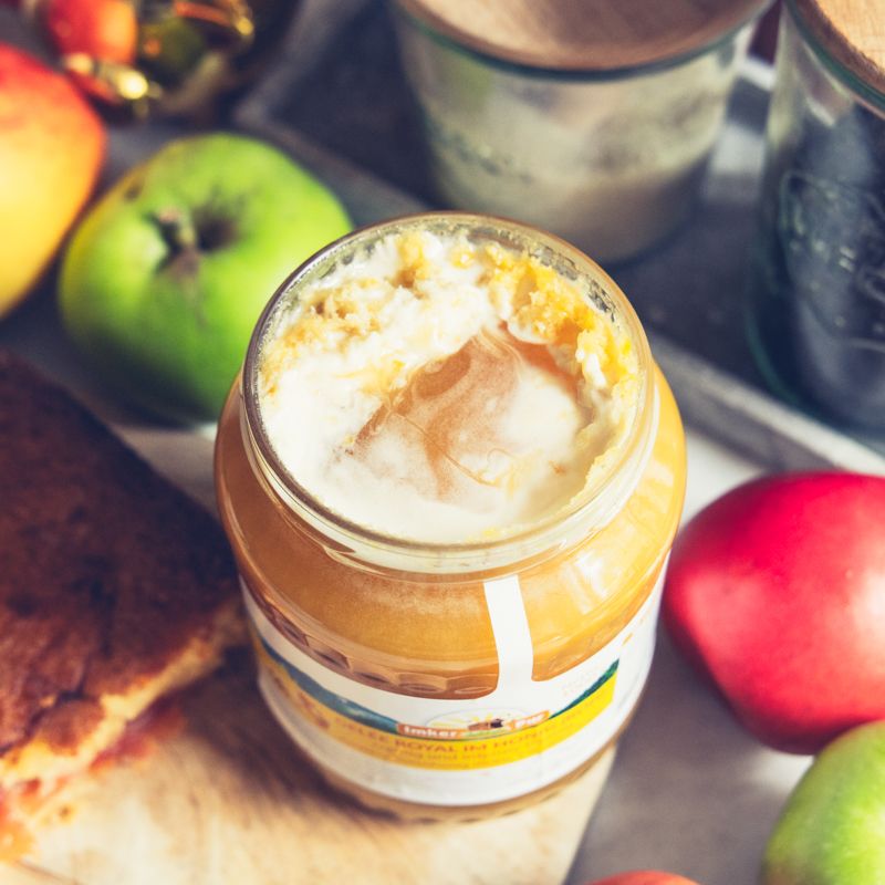 Geöffnetes Glas Honig mit Etikett. Aufschrift: Gelee Royal im Honig (roh). Goldener Deckel, weißes Etikett. Honig mit cremiger Schicht.
