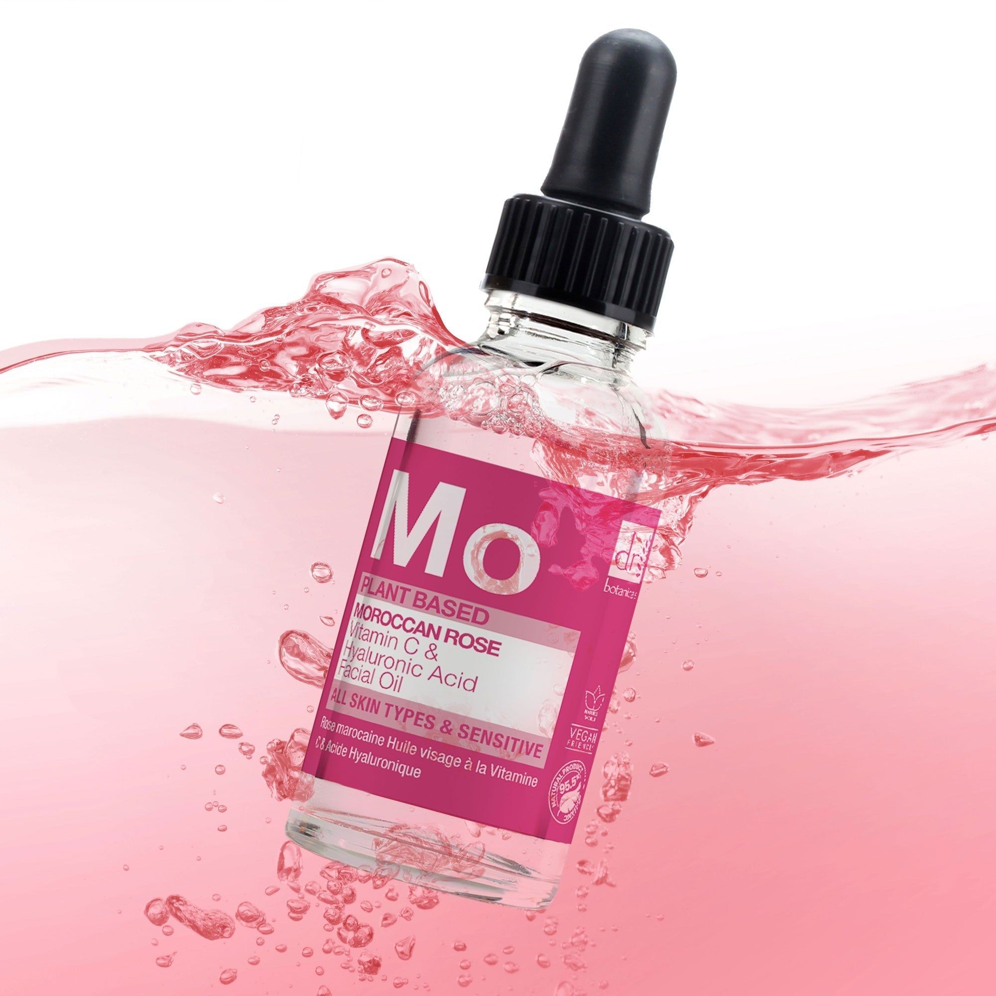 Gesichtsölflasche in rosa Flüssigkeit. Aufschrift: Moroccan Rose, Vitamin C & Hyaluronsäure. Schwarze Pipette. Klare Glasflasche.