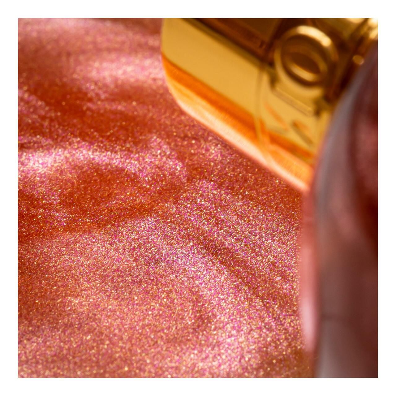Nahaufnahme des Molton Brown Rose Dunes Bade- & Duschgels. Rosa Flüssigkeit mit Glitzer, goldener Verschluss.