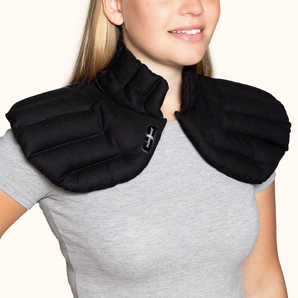 Schwarzes Wärmekissen Embrace, um den Hals einer Person getragen. Mit Label. Gepolstert und gesteppt.