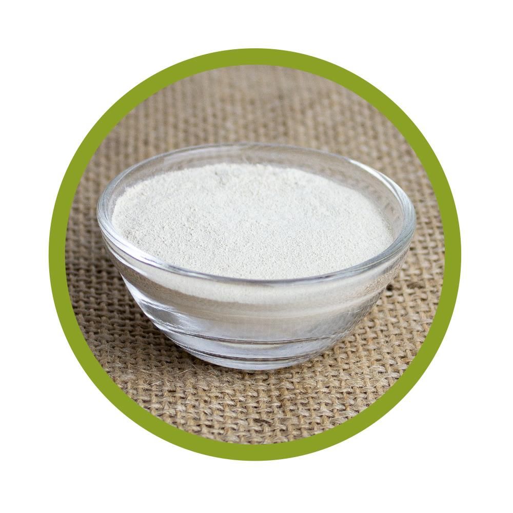 Runde Nahaufnahme einer Glasschale mit weißem Pulver auf einem groben Stoff.