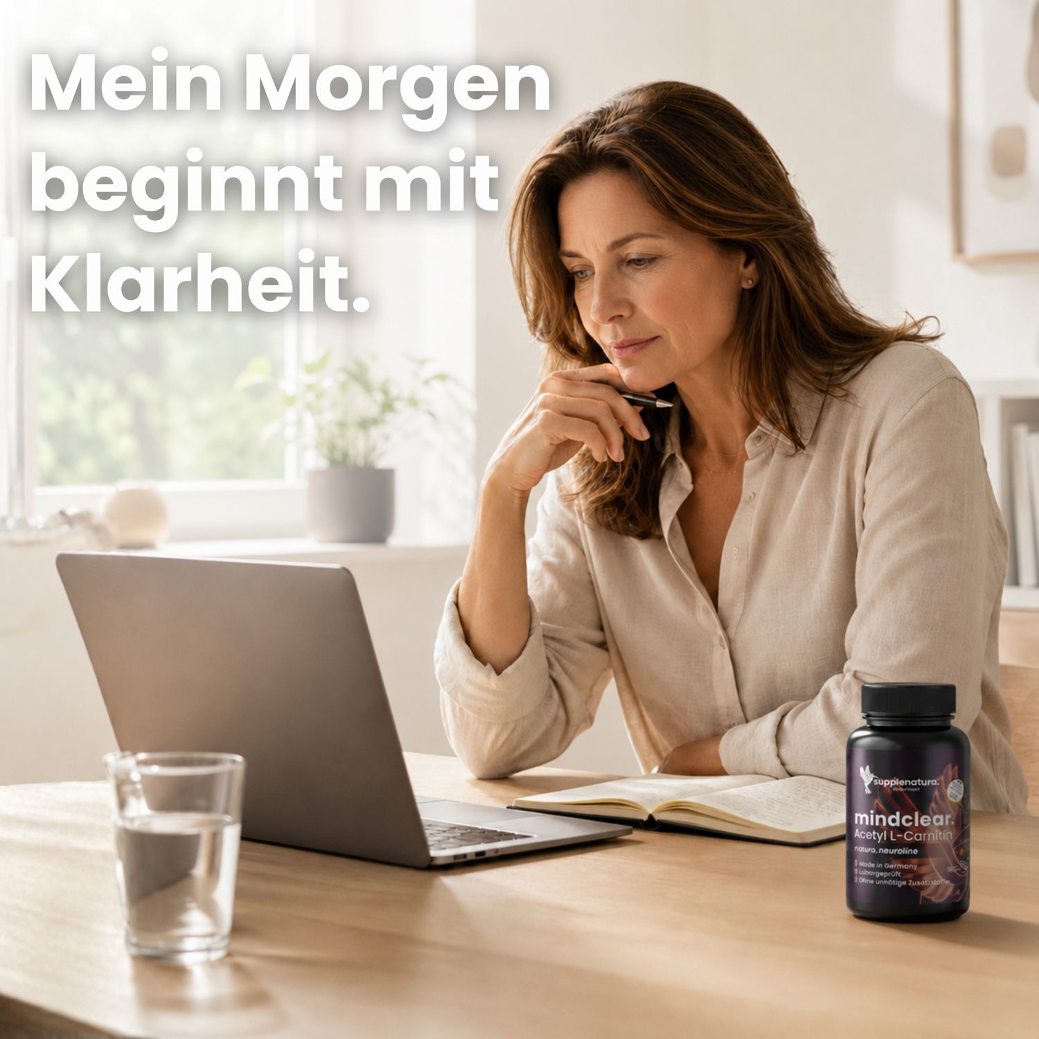 Frau am Schreibtisch mit Laptop und einer Flasche Mindclear Acetyl L-Carnitin.
