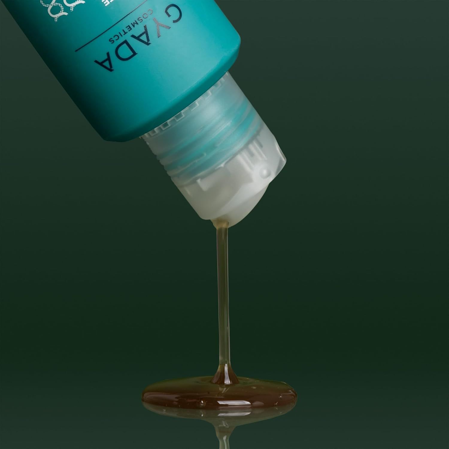 Türkise Flasche mit weißem Klappverschluss, aus der Flüssigkeit tropft.