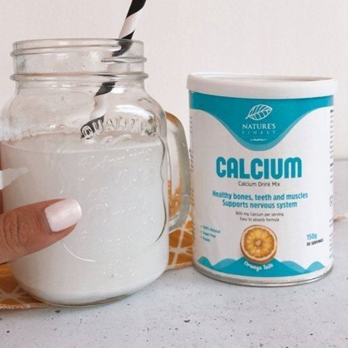 Nature's Finest Calcium Dose neben einem Glas mit Calcium-Getränk und Strohhalm.