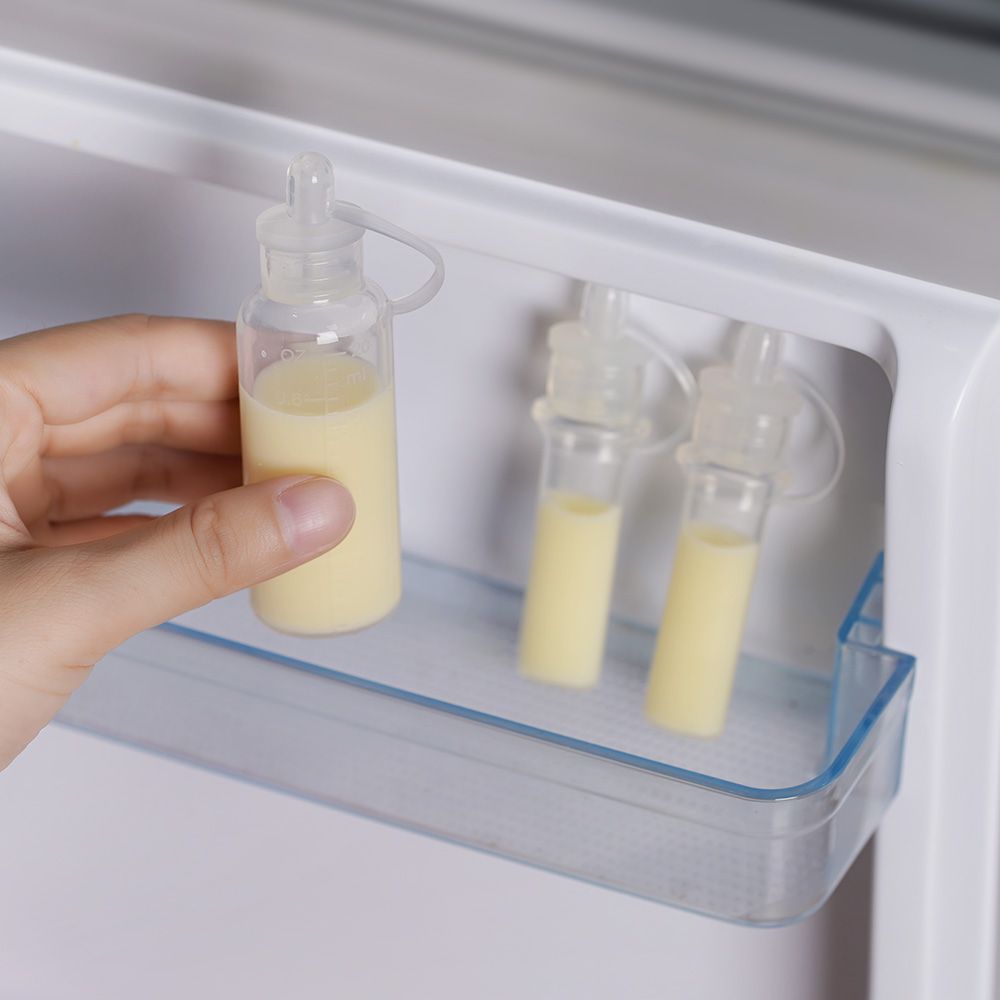 Drei transparente Behälter mit gelblicher Flüssigkeit in einem Kühlschrank. Eine Hand greift nach einem Behälter.