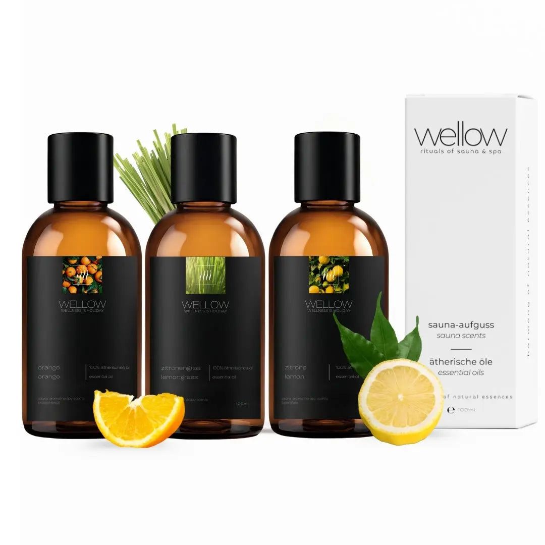 Drei Flaschen ätherischer Öle mit schwarzen Etiketten und einer weißen Verpackung. Limone, Orange und Citronella.