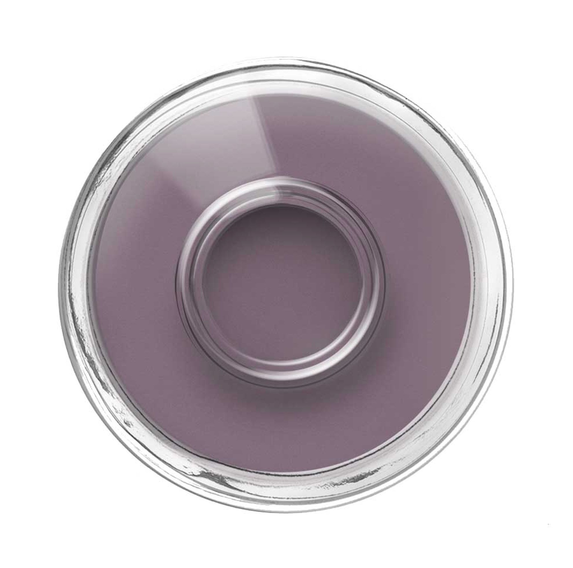 Draufsicht auf eine Nagellackflasche. Lila Farbe im Inneren, klarer Glasrand.