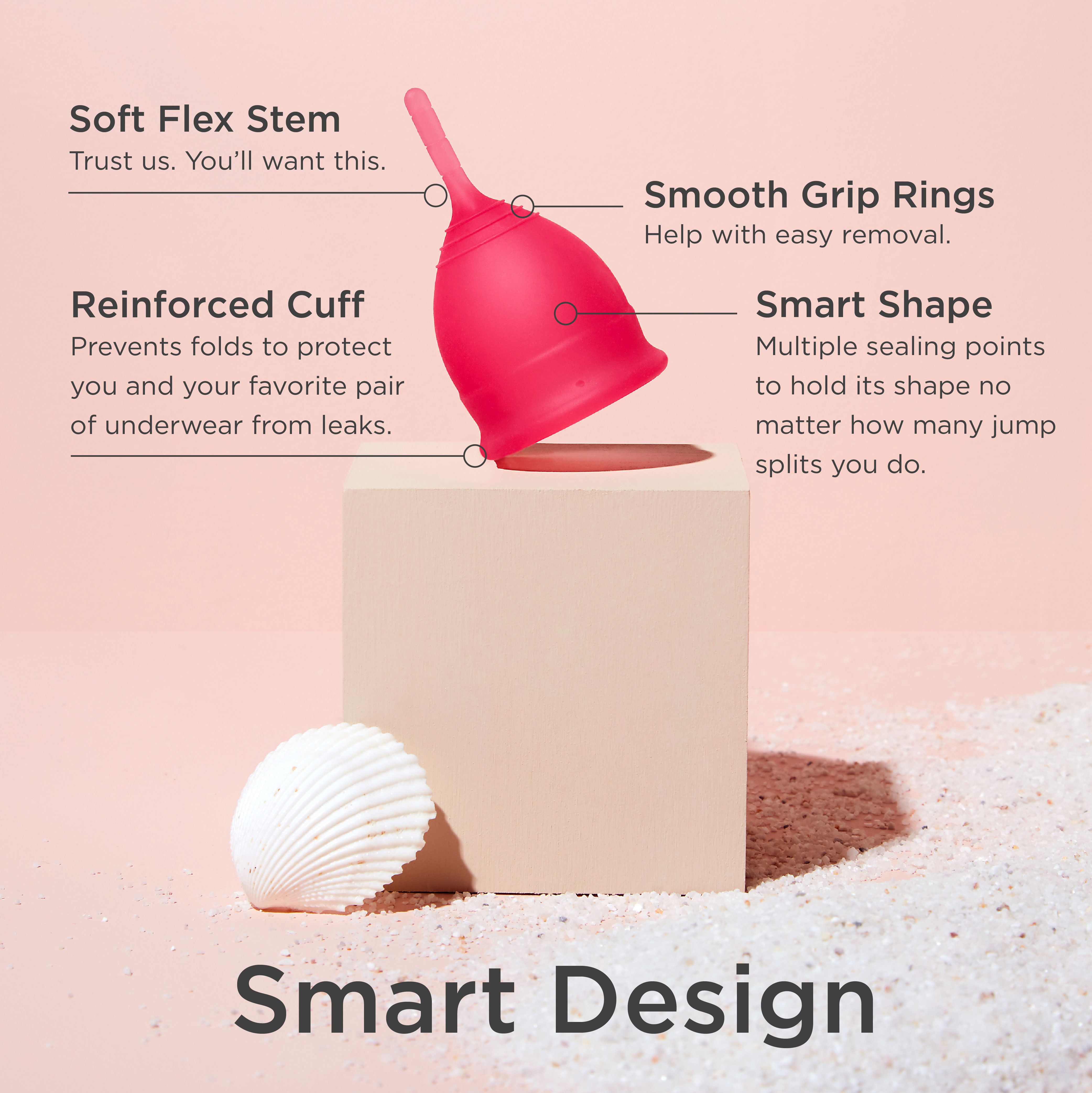 Roter Menstruationsbecher mit Griff, Ringe und verstärktem Rand. Auf einem Podest mit Muschel.