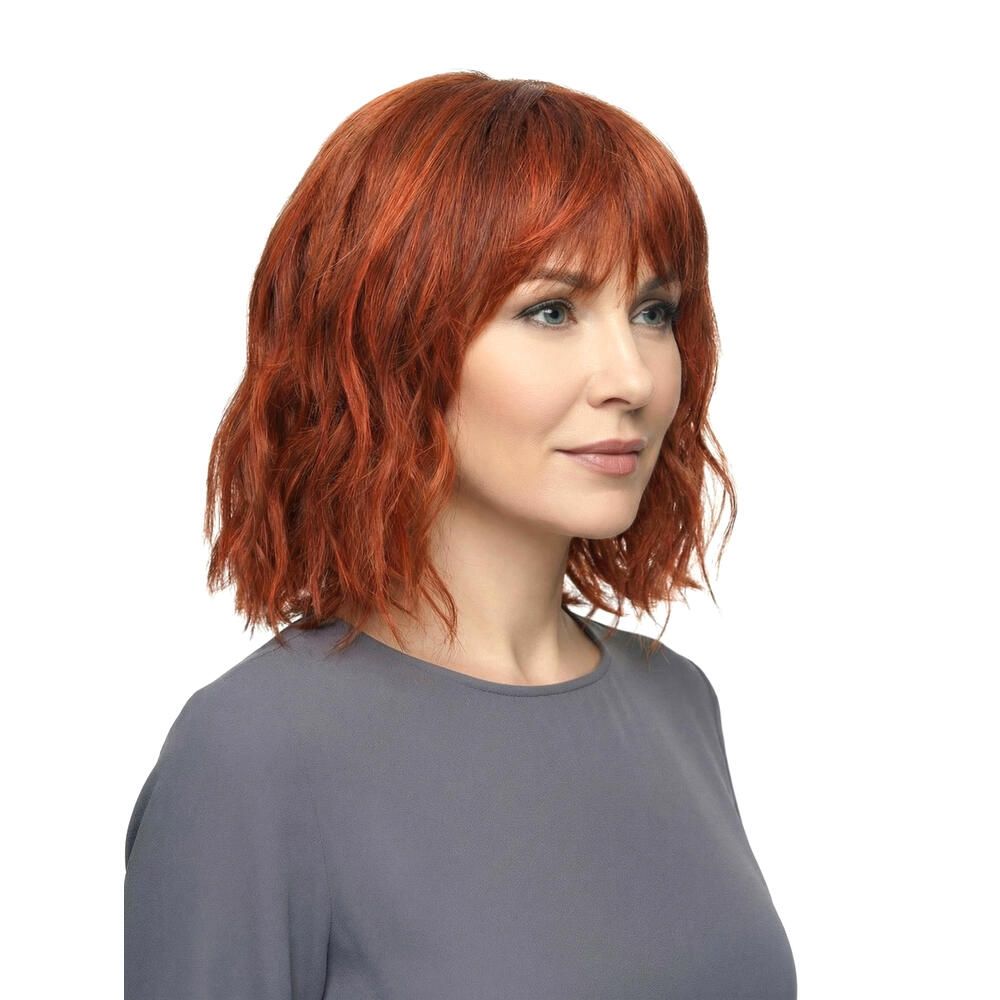 Rote Perücke mit Pony. Die Frau trägt ein graues Oberteil. Seitenansicht.
