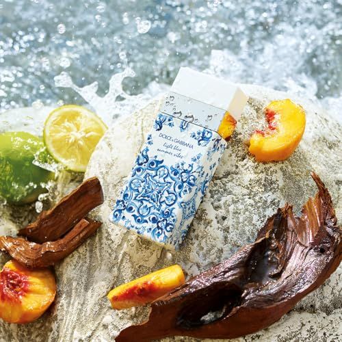 Flakon und Verpackung Dolce & Gabbana Light Blue Summer Vibes. Auf Stein. Früchte und Wasser. Blaues Muster.