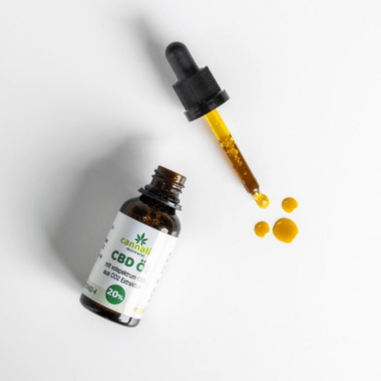 Braune Glasflasche mit Tropfer und gelben Flüssigkeitstropfen. Aufschrift: CBD Öl, Cannalin, 20%. Flasche und Tropfer auf weißem Hintergrund.