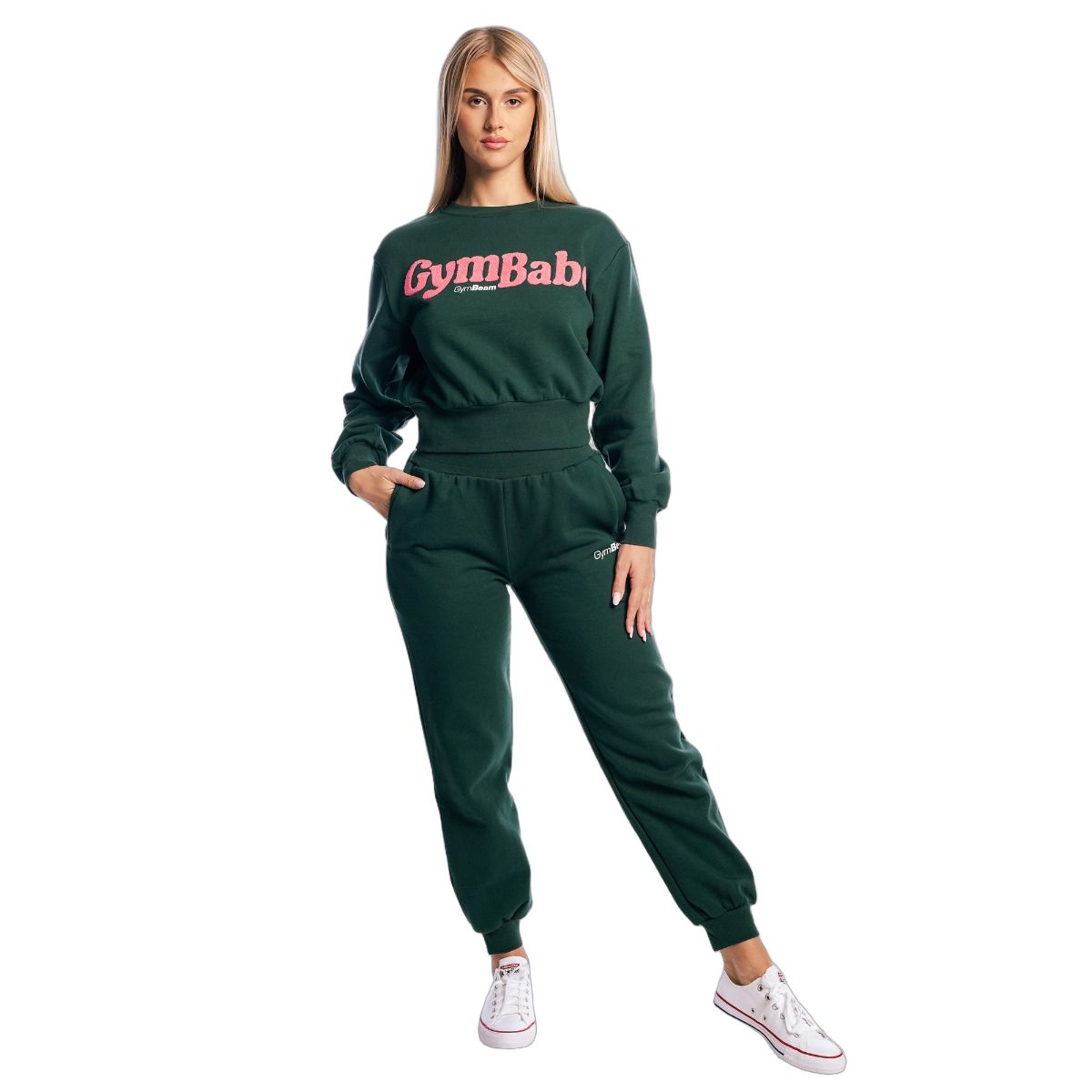Ganzkörperansicht einer Frau im grünen Set: Pullover cropped Langarm Forest und Jogginghose.