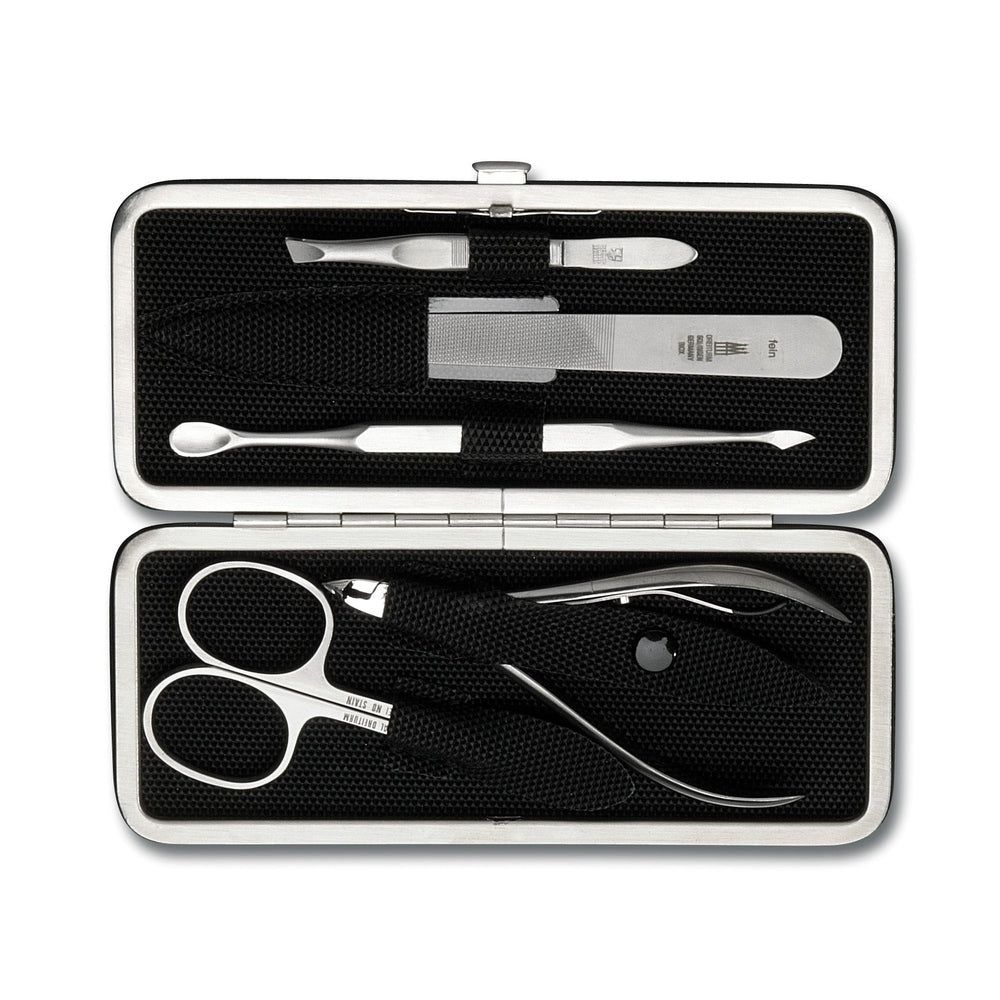 Maniküre-Set in silberfarbener Metallbox. Enthält Nagelschere, Feile, Pinzette und weitere Werkzeuge. Schwarzes Innenfutter.