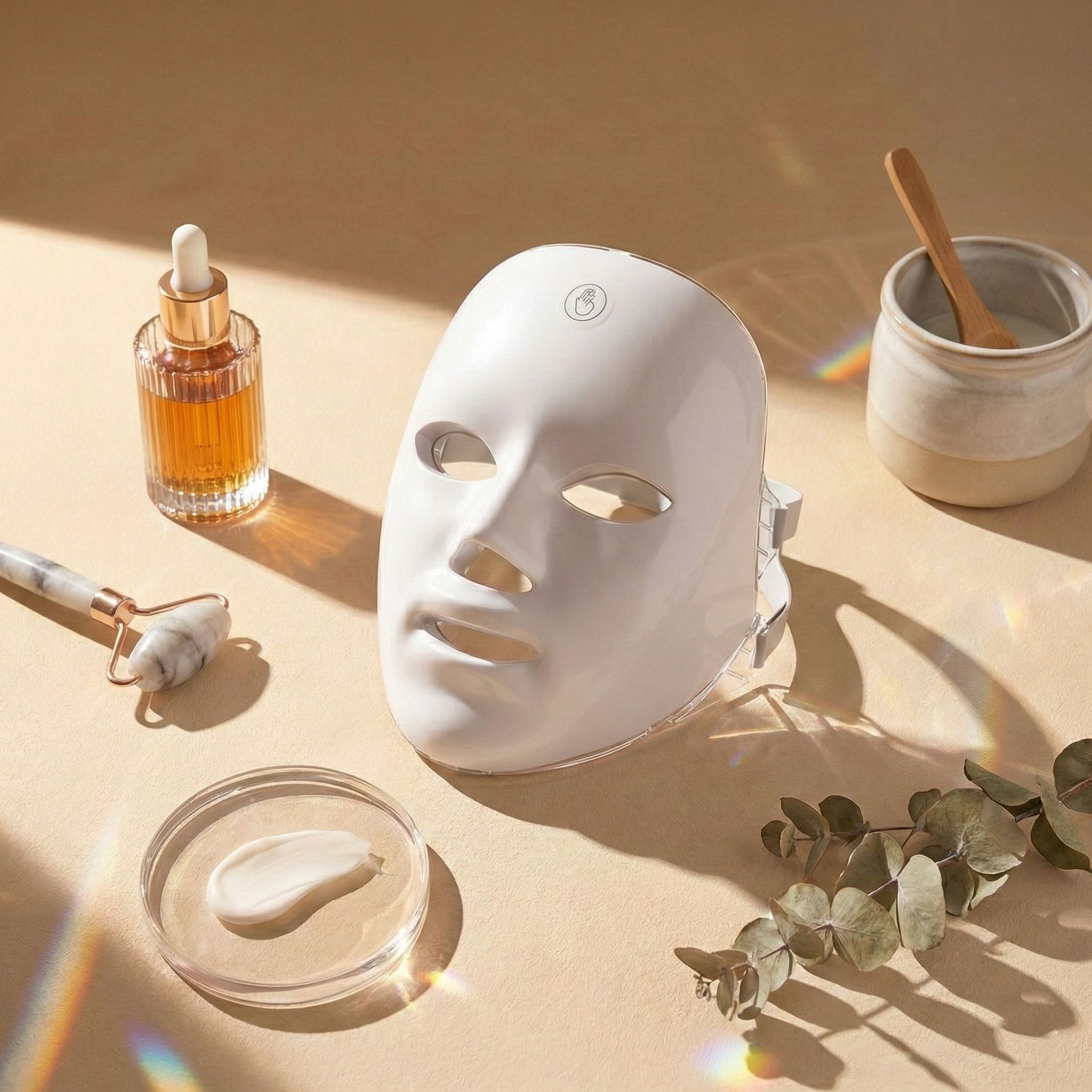 LED-Lichttherapie-Maske mit Hautpflegeprodukten wie Serum und Gesichtsroller.